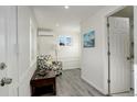 Bright living room with wood floors, mini split unit, and fresh white paint at 4835 Grove St, Denver, CO 80221
