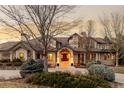 Elegant front entrance featuring a covered porch, manicured shrubs, and a grand wooden front door at 4041 E Forbes Ct, Greenwood Village, CO 80121