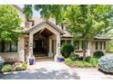 Covered front entrance with stone pillars, manicured landscaping, and elegant lighting fixtures creating a welcoming approach at 4041 E Forbes Ct, Greenwood Village, CO 80121