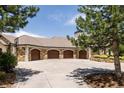 Attached four-car garage with stylish wood doors, a basketball hoop, and a spacious driveway at 4041 E Forbes Ct, Greenwood Village, CO 80121