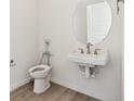 White half-bathroom with a round mirror at 11475 E Briarwood Cir, Centennial, CO 80112