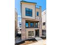 Modern three-story home featuring a brick facade and a second-story balcony at 11475 E Briarwood Cir, Centennial, CO 80112