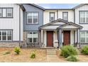 Townhome with a covered porch and stone accents; table and chairs on the front patio at 193 Ambrose St, Erie, CO 80516