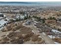 Expansive aerial view of luxury home shows the surrounding landscape and neighborhood with rolling hills and mature trees at 3520 Castle Butte Dr, Castle Rock, CO 80109