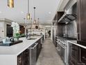 Modern kitchen with stainless steel appliances, a spacious island, and dark cabinetry at 3520 Castle Butte Dr, Castle Rock, CO 80109
