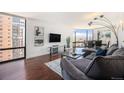 Modern living room featuring hardwood floors, city views, and a comfortable gray sofa at 1625 Larimer St # 2601, Denver, CO 80202