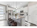 Modern kitchen with white cabinets, granite island, and stainless steel appliances at 21795 E 8Th Ave, Aurora, CO 80018