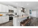 Modern kitchen with white cabinets, granite island, and stainless steel appliances at 21795 E 8Th Ave, Aurora, CO 80018