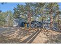 Stylish home with a yellow door and mature trees offering shade and curb appeal at 638 Kinnikinnik Hl, Golden, CO 80401