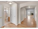 Hallway with hardwood floors leading to a full bathroom and the living room with a fireplace at 23612 E Mississippi Cir, Aurora, CO 80018