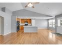 Open-concept living room with hardwood floors, vaulted ceilings, an adjacent kitchen with island at 23612 E Mississippi Cir, Aurora, CO 80018