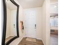 Bright entryway with wood floors, coat rack, and a large mirror provides a welcoming first impression at 2243 Villageview Ln, Castle Rock, CO 80104