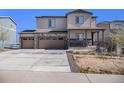 Charming two-story home featuring a stone facade, three-car garage, and covered front porch at 2243 Villageview Ln, Castle Rock, CO 80104
