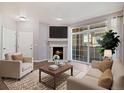 Cozy living room featuring a fireplace, large windows, and comfortable seating, perfect for relaxing and entertaining at 3890 S Dayton St # 105, Aurora, CO 80014
