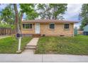 Quaint brick home with a front yard and sidewalk leading to the front door at 5274 Alkire St, Arvada, CO 80002