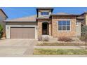 Charming stone-accented home featuring a tile roof and well-maintained landscaping at 15265 W Baker Ave, Lakewood, CO 80228