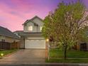 Inviting two-story home with a well-manicured lawn, two-car garage, and a basketball hoop on the driveway at 4436 Windmill Dr, Brighton, CO 80601