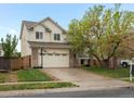 Inviting two-story home featuring a well-kept lawn, brick accents, and convenient two-car garage at 4436 Windmill Dr, Brighton, CO 80601