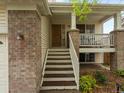 Welcoming front porch with steps leading up to the home, complemented by brick and siding at 4436 Windmill Dr, Brighton, CO 80601