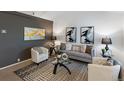 Modern living room with grey sofa, stylish rug, and contemporary artwork, perfect for relaxing at 4436 Windmill Dr, Brighton, CO 80601