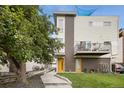 Contemporary home with a yellow door, balcony, and well-maintained landscaping at 1711 Hooker St # 2, Denver, CO 80204