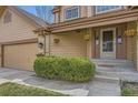 A welcoming front entrance with potted plants, and a covered porch with hanging baskets at 1604 Brookside Dr, Highlands Ranch, CO 80126