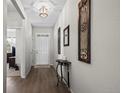 Hallway boasts hardwood floors, decorative wall art, and a view of the front door at 401 Clubhouse Dr, Fort Lupton, CO 80621