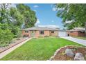 Charming brick home with a well-manicured lawn, walkway, and green front door at 9150 Fir Dr, Thornton, CO 80229