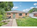 Charming brick home with a well-manicured lawn, walkway, and green front door at 9150 Fir Dr, Thornton, CO 80229