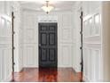 Grand foyer featuring wainscoting, hardwood floors, and striking black front door at 2 Fieldstone Trl, Englewood, CO 80113