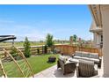 Inviting backyard featuring stylish outdoor furniture, a cozy fire pit, and well-manicured artificial grass at 864 Clover Loop, Erie, CO 80026