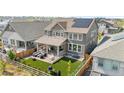 Aerial view of a home showcasing a landscaped backyard with a covered patio and artificial grass at 864 Clover Loop, Erie, CO 80026