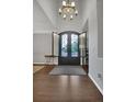 Grand foyer features an elegant chandelier, high ceilings, beautiful hardwood floors, and custom iron double doors at 877 Eldorado Dr, Superior, CO 80027