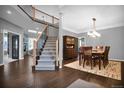 Open-concept living and dining areas boast a staircase, hardwood floors, stone fireplace, and elegant light fixtures at 877 Eldorado Dr, Superior, CO 80027