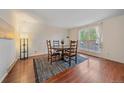 Bright dining area with hardwood floors, a round table, and natural light streaming through a large window at 2166 S Joplin Way, Aurora, CO 80013