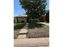 Modest home with mature trees and a red garage door at 460 Yates St, Denver, CO 80204