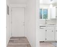 Bright entryway and kitchen area with white cabinets and modern appliances at 943 Pinon Ct, Longmont, CO 80504