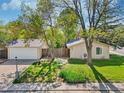 Well-maintained front yard with lush greenery, detached garage, and inviting exterior at 943 Pinon Ct, Longmont, CO 80504