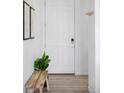 Bright entryway with a white front door, a wooden bench, and light wood floors at 6117 Easton Cir, Frederick, CO 80504