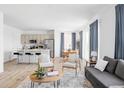 Open-concept living room with bright light, stylish furniture, and a view of the modern kitchen at 6117 Easton Cir, Frederick, CO 80504