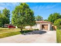 Charming home featuring an attached garage, large tree, and a well-maintained front yard at 3055 S Winona Ct, Denver, CO 80236