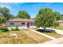 Well-maintained single-story home with fresh exterior paint, lush front yard and mature trees at 3055 S Winona Ct, Denver, CO 80236