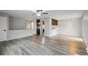 Open-concept living space with gray hardwood floors, combining kitchen and living area at 3746 S Fairplay Way, Aurora, CO 80014