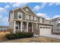 Charming two-story house with a front porch and two-car garage, complemented by a well-kept lawn at 16317 Saint Paul St, Thornton, CO 80602