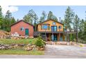 Charming mountain home with a large deck, rock landscaping, and a detached garage at 10090 Blue Sky Trl, Conifer, CO 80433