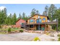 Charming mountain home with a large deck, rock landscaping, and a detached garage at 10090 Blue Sky Trl, Conifer, CO 80433