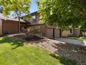 Well-maintained home with brick accents, mature trees, and a welcoming landscaped front yard at 12674 E Bates Cir, Aurora, CO 80014