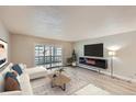 Open-concept living room boasts a fireplace, modern decor, recessed lighting, and glass sliding doors to the outside at 675 S Alton Way # 7A, Denver, CO 80247