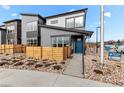 Contemporary two-story home showcases modern architecture, blue front door, and low maintenance yard at 9487 W 58Th Ln # C, Arvada, CO 80002