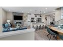 Open concept living space featuring a modern fireplace, kitchen island, and dining area at 9487 W 58Th Ln # C, Arvada, CO 80002